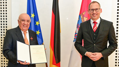 Nasser Djafari und Sozialminister Klose bei der Überreichung des Verdientskreuzes, beide lächeln in die Kamera