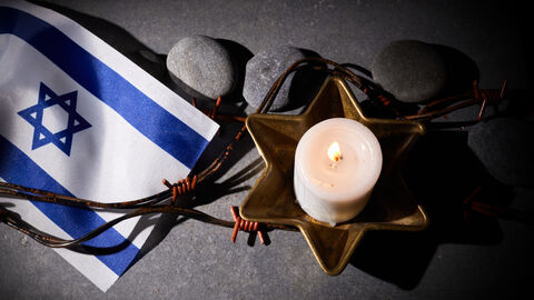 Eine Kerze und eine Israelflagge erinnern an die Reichspogromnacht Eine Kerze und eine Israelflagge erinnern an die Reichspogromnacht