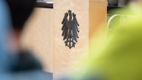 Ein Rednerpult mit schwarzem Bundesadler in der Nahaufnahme