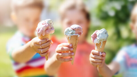 Sommergefühle Drei Kinder halten ihre Eiswaffeln in die Kamera. Die Sonne scheint, das Eis schmilzt.