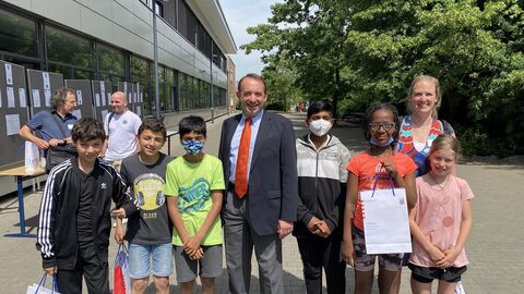 Kultusminister Lorz steht in der Mitte. Neben ihm sind Schülerinnen und Schüler der Schule Bensheim. Sie schauen lächelnd in die Kamera.