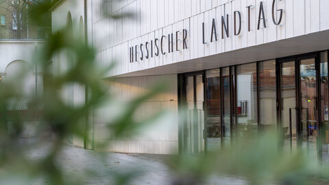 Aufnahme vom Eingangsbereich des hessischen Landtags. Zu sehen ist der Schriftzug "Hessischer Landtag"  über der Tür.